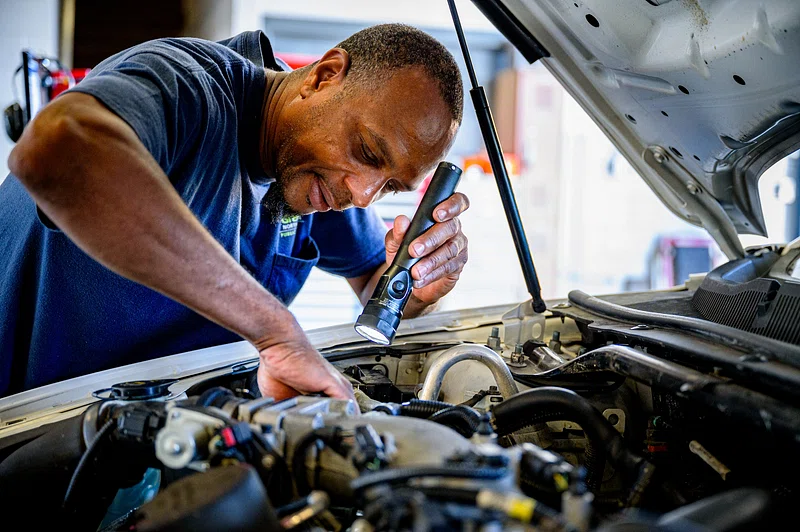 Technician inspecting vehicle engine