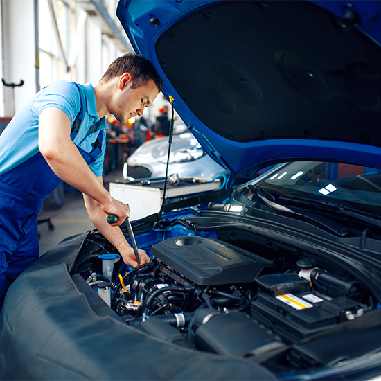Technician working on vehicle engine